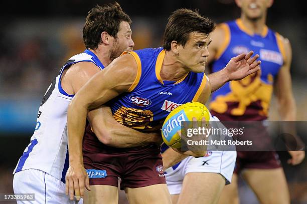 Jed Adcock of the Lions looks to handball during the round 16 AFL match between the Brisbane Lions and the North Melbourne Kangaroos at The Gabba on...