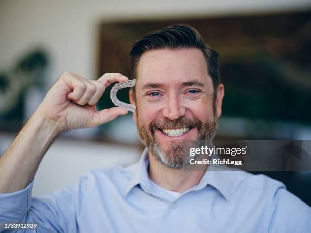 man with invisible teeth aligners - invisalign stockfoto's en -beelden