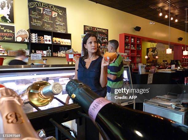 France-cheese-food-health-distribution Jill Erber, the owner of Cheestique, holds a piece of mimolette cheese in her her shop in Arlington, Virginia,...