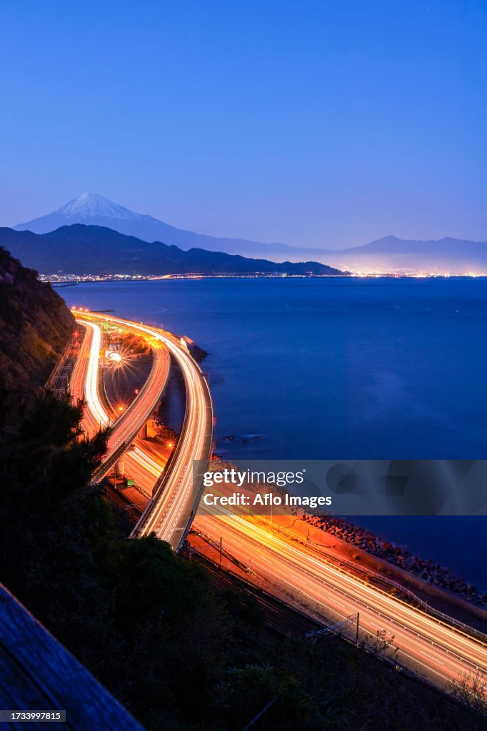 Night view of Mount Fuji and highway from Satta ridge at sunset, Shizuoka Prefecture, Japan
