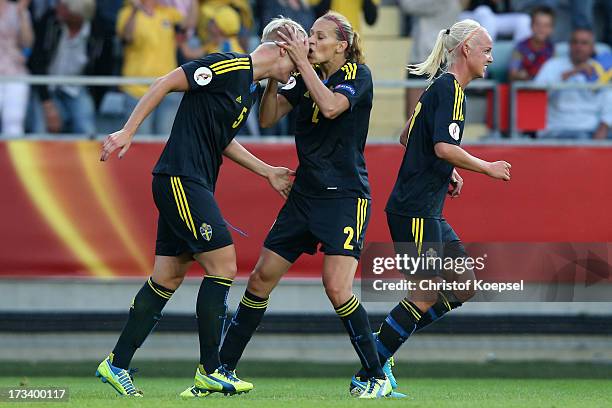 Charlotte Rohlin of Sweden kisses Nilla Fischer of Sweden after she had scored the first goal during the UEFA Women's EURO 2013 Group A match between...