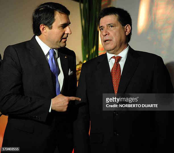 Paraguayan President Federico Franco talks with President-elect Horacio Cartes during the opening of an industial and agricultural fair in Mariano...