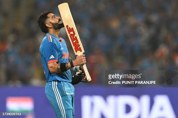 India's Virat Kohli celebrates after scoring a century during the 2023 ICC Men's Cricket World Cup one-day international match between India and...