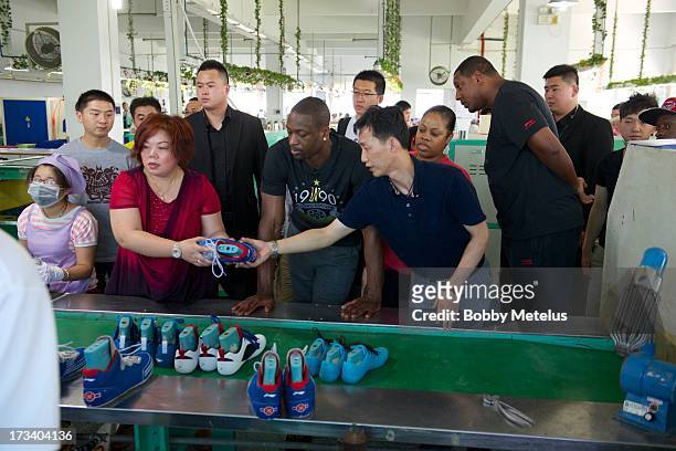Dwyane Wade receives a tour around the Li-Ning shoe manufacturing factory where his "Way of Wade" brand is produced on July 12, 2013 in Tai Cang,...