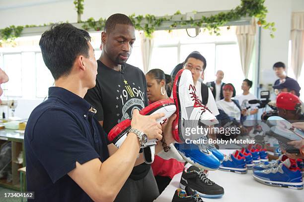 Dwyane Wade inspects a new batch of "Way of Wade" shoes for quality control at the Li-Ning shoe manucaturing factory on July 12, 2013 in Tai Cang,...