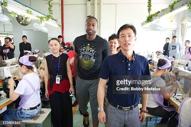 Dwyane Wade receives a tour around the Li-Ning shoe manufacturing factory where his "Way of Wade" brand is produce on July 12, 2013 in Tai Cang,...