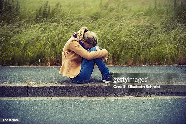 girl sitting on sidewalk, hiding face - hugging knees stock pictures, royalty-free photos & images