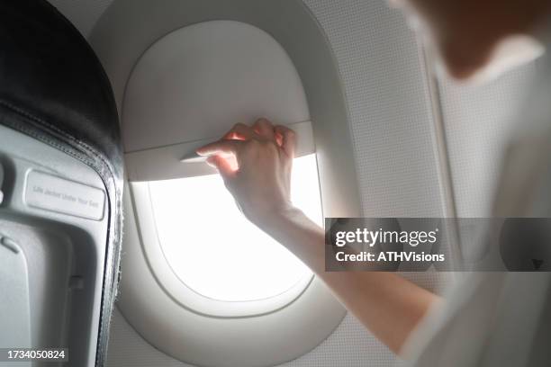 close-up woman hand open the airplane window while travel - window blinds stock pictures, royalty-free photos & images