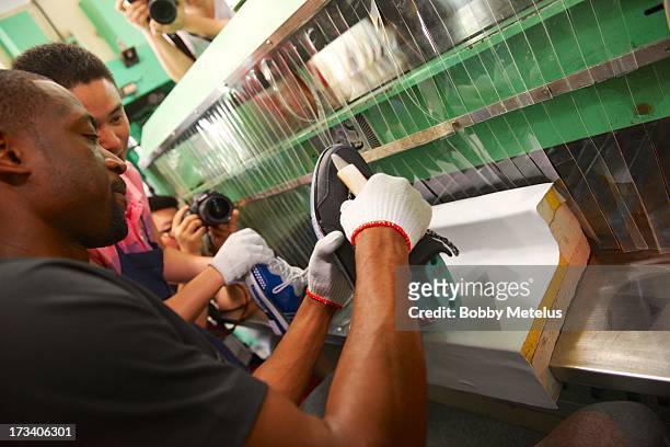 Dwyane Wade joins the assembly line and works on the sole of his new 'Way of Wade Encore "Team No Sleep"' shoe at the Li-Ning shoe manufacturing...
