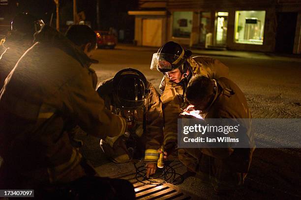 Firefighters check for hazardous gasses in the storm drains of July 13, 2013 in Lac-Megantic, Quebec, Canada. A train derailed and exploded into a...