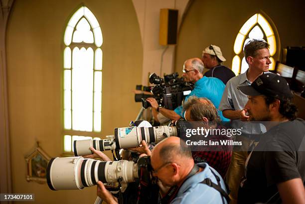 Members of the media photograph residents of Lac-Megantic as they gather and pray at the Presbyteres-Eglises Catholiques July 13, 2013 in...
