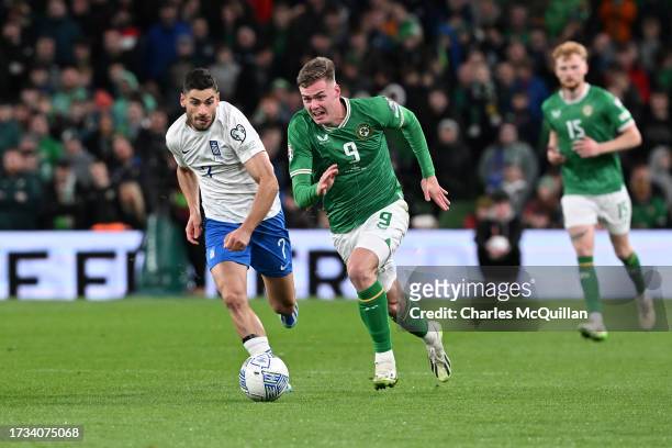 Evan Ferguson Republic of Ireland runs with the ball under pressure from Giorgos Masouras of Greece during the UEFA EURO 2024 European qualifier...