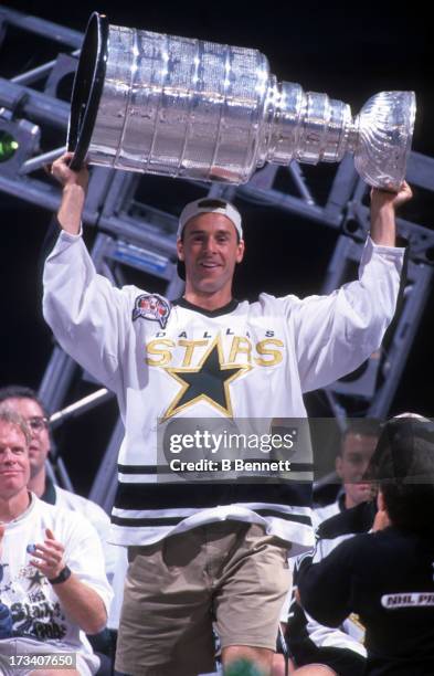 Joe Nieuwendyk of the Dallas Stars holds the Stanley Cup Trophy during the 1999 Stanley Cup Parade after defeating the Buffalo Sabres in Game 6 of...