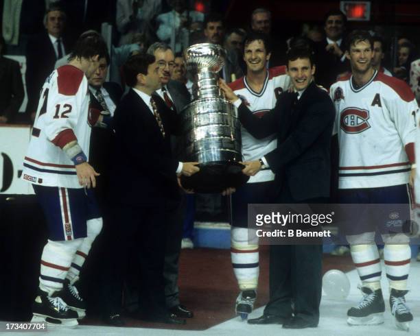 Commissioner Gary Bettman presents the Stanley Cup Trophy to Denis Savard, Guy Carbonneau, Kirk Muller and Mike Keane of the Montreal Canadiens after...
