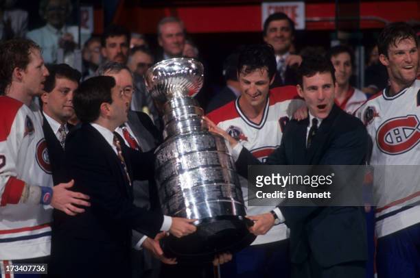 Commissioner Gary Bettman presents the Stanley Cup Trophy to Denis Savard, Guy Carbonneau, Kirk Muller and Mike Keane of the Montreal Canadiens after...