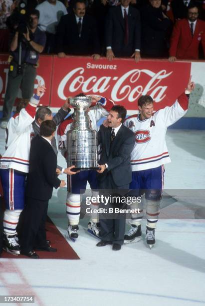 Commissioner Gary Bettman presents the Stanley Cup Trophy to Denis Savard, Guy Carbonneau, Kirk Muller and Mike Keane of the Montreal Canadiens after...