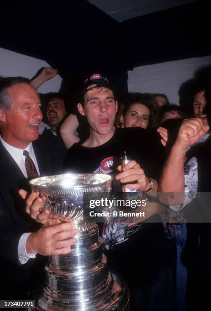 Denis Savard of the Montreal Canadiens celebrates with the Stanley Cup Trophy in the locker room after defeating the Los Angeles Kings in Game 5 of...