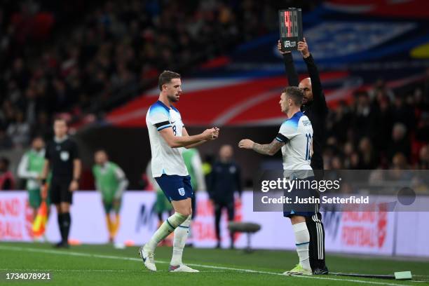 Jordan Henderson gives the captains armband to Kieran Trippier of England as they are substituted during the international friendly match between...