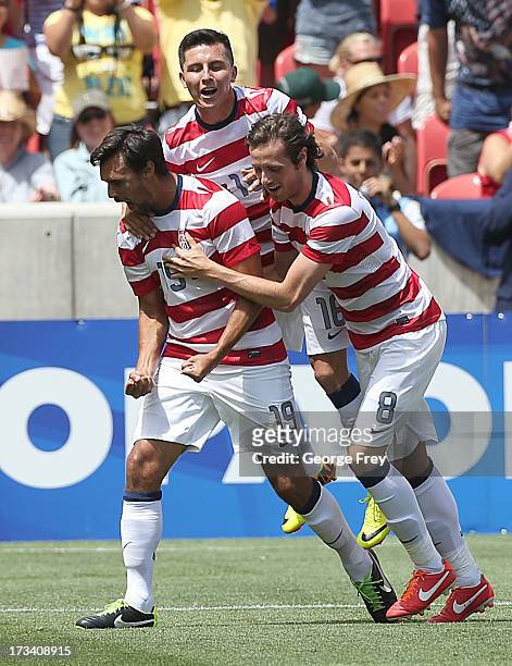 Chris Wondolowski of the United States celebrates his goal with his teammates Herculez Gomez and Jose Torres during a game against Cuba in the second...
