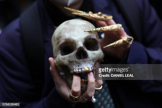 Protester holds a human skull model at a march for the climate in London, on October 19 during a week of demonstrations by climate activists in the...