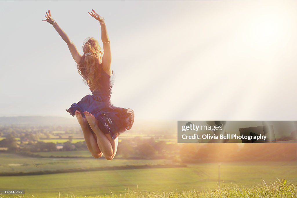 Young women jumping towards sunshine