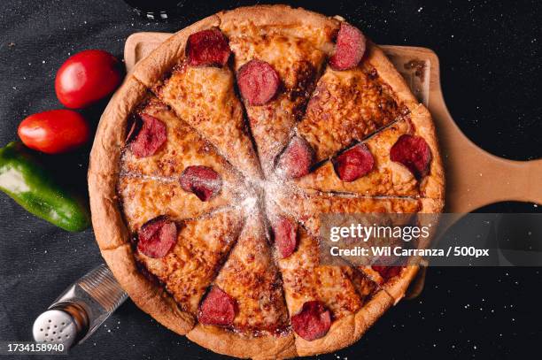 directly above shot of pizza on table - pizza temptation stock pictures, royalty-free photos & images