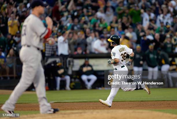 Derek Norris of the Oakland Athletics trots around the bases after hitting a solo home run as pitcher Jon Lester of the Boston Red Sox looks on with...