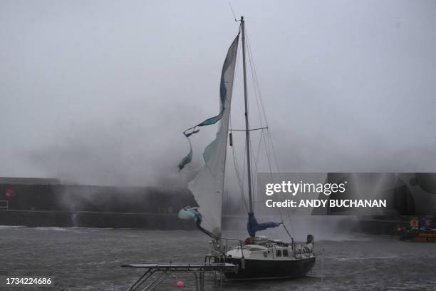 The sail of a yacht is seen torn by the strong winds inside the harbour in Stonehaven on the east coast of Scotland on October 19 as wind and rain...