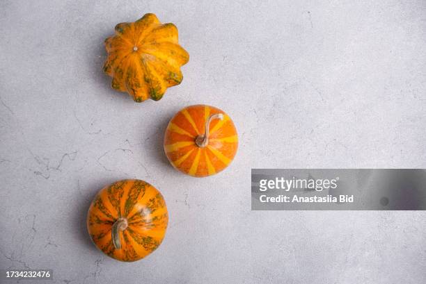 several jack be little pumpkins on grey marble background.good as autumn background with negative space. - jack be little squash ストックフォトと画像