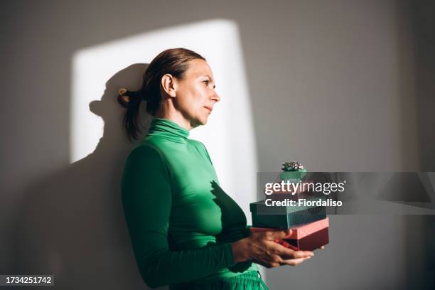 red and green shiny gift boxes in female hands - exchanging gifts stock pictures, royalty-free photos & images