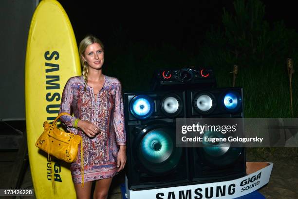 Nicky Hilton sizes up the brand new sound system from Samsung at their #GigaSoundBlast Summer DJ series at Surf Lodge on July 13, 2013 in Montauk,...