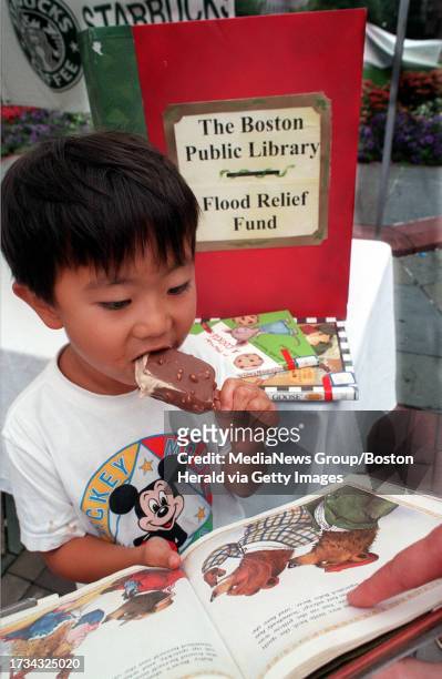 Eric Li of New Jersey samples a coffee ice cream bar made by Starbucks as he reads a book across from the Boston Public Library. For each individual...