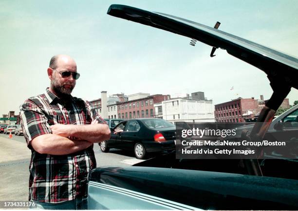 Broke down on Rte 93- 44 yr. Old Rick Martin stands beside his '85 Chevy Suburban which overheated due to traffic back caused by shifting of the...