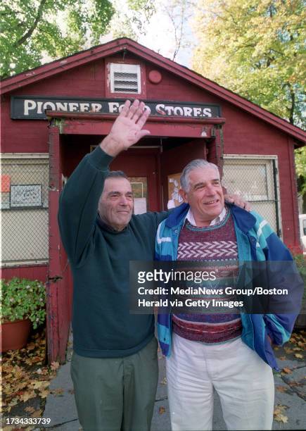 Charlie Nichols waves to a passerby outside the Pioneer Food Store he has run for 50 years in West Roxbury. With him is brother Ted, who worked with...