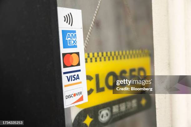 Sticker for American Express, Mastercard, Visa and Discover credit cards displayed at a business in New York, US, on Tuesday, Oct. 17, 2023. American...