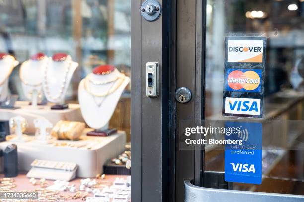 Sticker for Mastercard, Visa and Discover credit cards displayed on a street cart in New York, US, on Tuesday, Oct. 17, 2023. American Express Co.,...