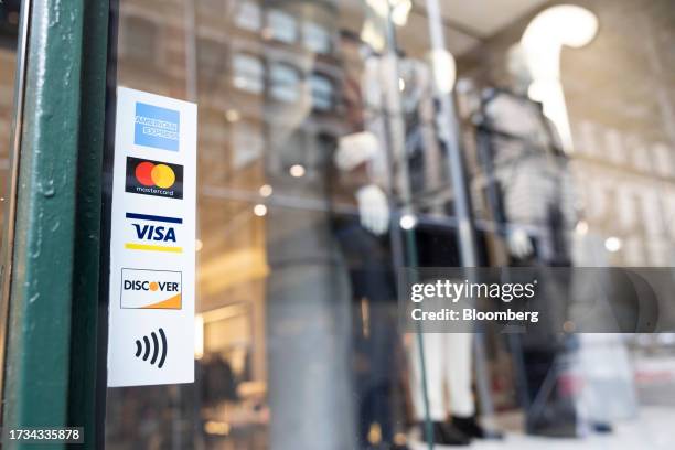 Sticker for American Express, Mastercard, Visa and Discover credit cards displayed on a street cart in New York, US, on Tuesday, Oct. 17, 2023....