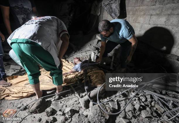 Personnel carry a civilian at the scene of destruction after an Israeli attack on the Greek Orthodox Church in Gaza City, Gaza on October 20, 2023....