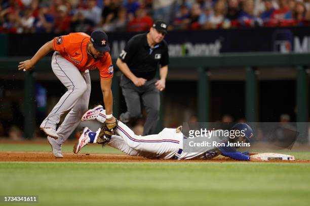 Marcus Semien of the Texas Rangers dives back to first base as Jose Abreu of the Houston Astros tags him out in the fifth inning during Game 4 of the...