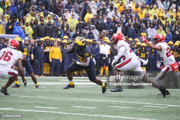 Michigan Wolverines running back Benjamin Hall runs with the ball while being pursued by Indiana defenders during a Big Ten Conference college...