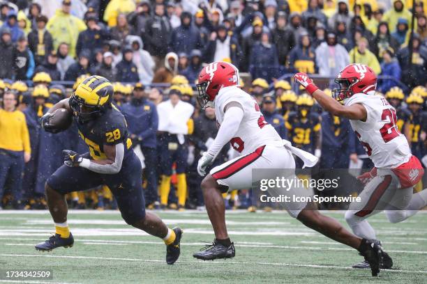 Michigan Wolverines running back Benjamin Hall runs with the ball while being pursued by Indiana defenders during a Big Ten Conference college...