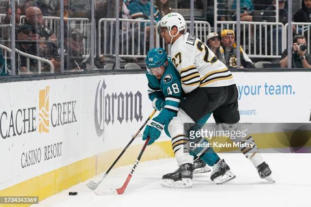 Tomas Hertl of the San Jose Sharks battles for the puck in the first period against Hampus Lindholm of the Boston Bruins at SAP Center on October 19,...