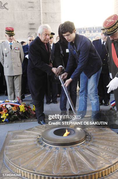 French Junior Minister for Veterans Affairs Alain Marleix and a student pay tribute to the unknown soldier at the Arc de Triomphe, 22 October 2007 in...