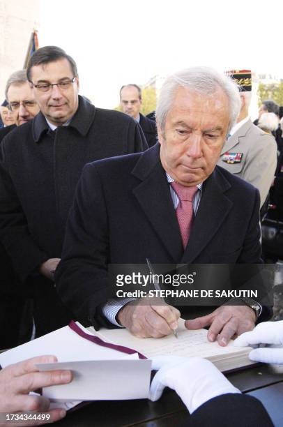French Junior Minister for Veterans Affairs Alain Marleix signs a golden book during a ceremony at the Arc de Triomphe, 22 October 2007 in Paris, as...