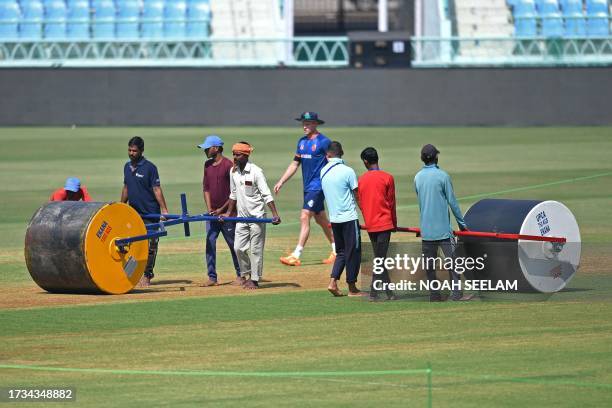 Groundmen run heavy rollers over the pitch on the eve of the 2023 ICC Men's Cricket World Cup one-day international match between Netherlands and Sri...