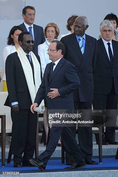 French President Francois Hollande walks past Malian President Dioncounda Traore during the Bastille Day parade on the Champs Elysees on July 14,...