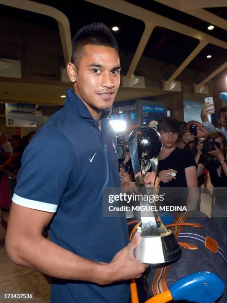 Under-20 French team goalkeeper Alphonse Areola poses with the trophy while arriving with his teammates at the Roissy-Charles-de-Gaulle airport, on...