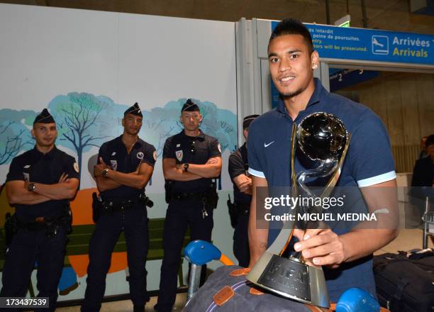 Under-20 French team goalkeeper Alphonse Areola poses with the trophy while arriving with his teammates at the Roissy-Charles-de-Gaulle airport, on...