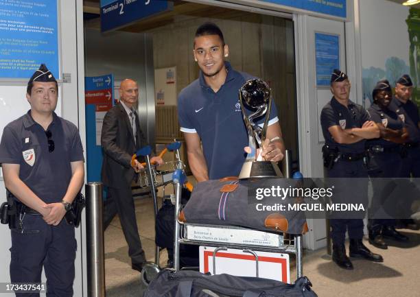 Under-20 French team goalkeeper Alphonse Areola poses with the trophy while arriving with his teammates at the Roissy-Charles-de-Gaulle airport, on...