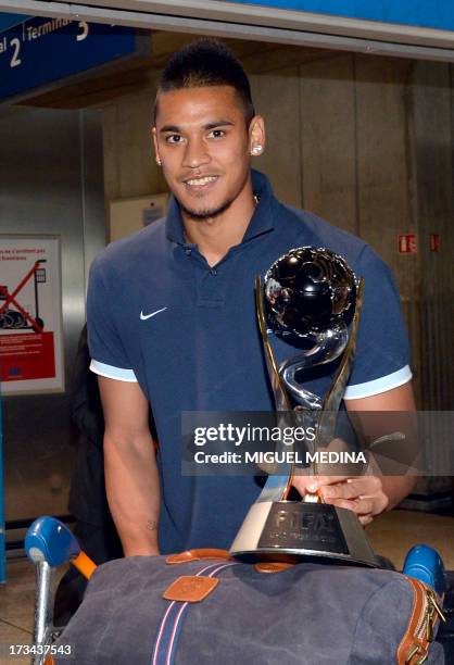 Under-20 French team goalkeeper Alphonse Areola poses with the trophy while arriving with his teammates at the Roissy-Charles-de-Gaulle airport, on...